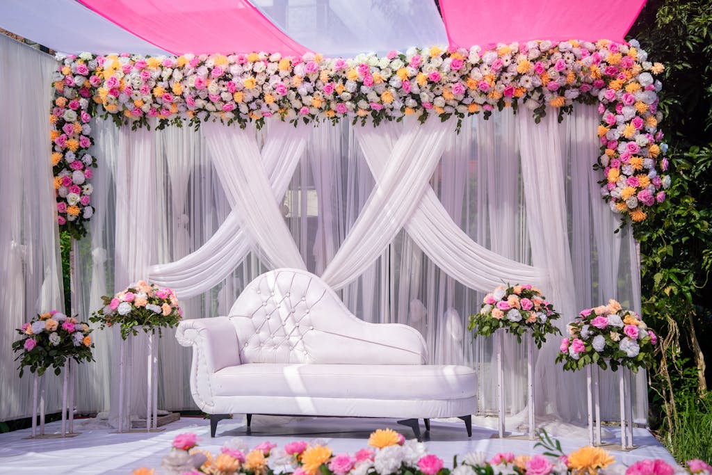 Luxurious wedding stage setup decorated with vibrant floral arrangements and a white sofa, perfect for celebrations.