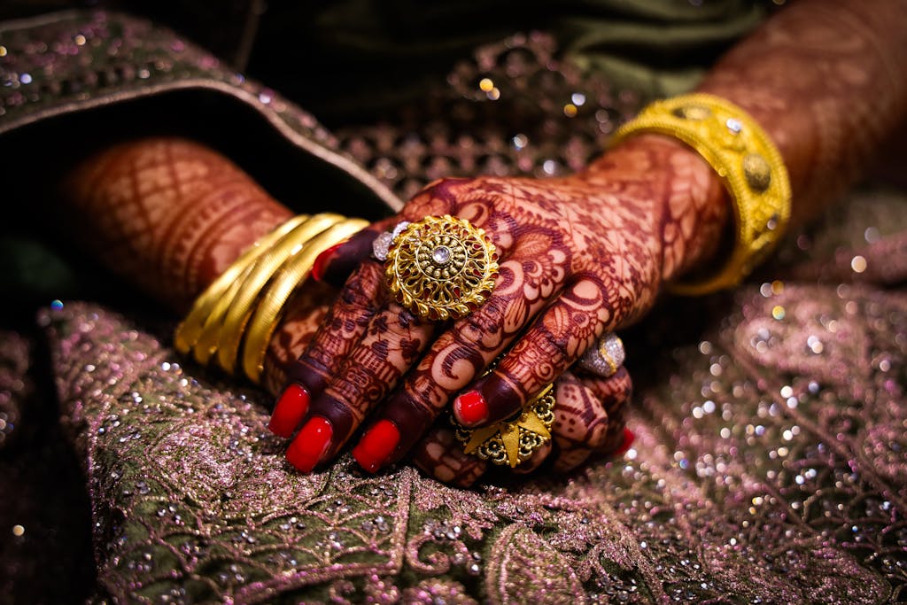 Close-up of beautifully hennaed hands with ornate jewelry, showcasing traditional culture in South India.