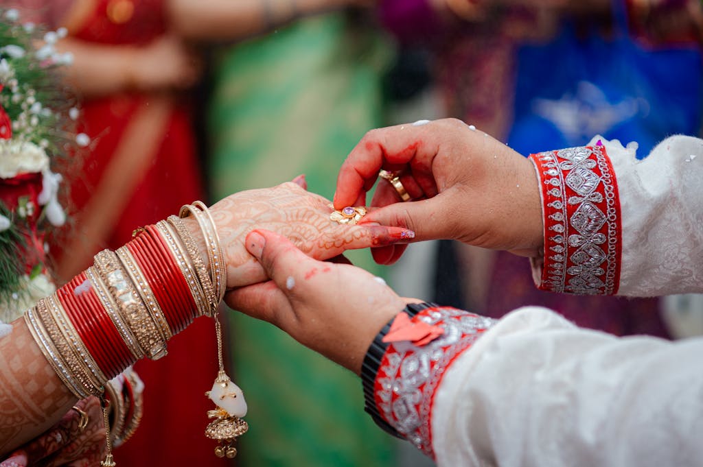 Close-up of couple exchanging rings in a vibrant traditional Indian wedding ceremony.
