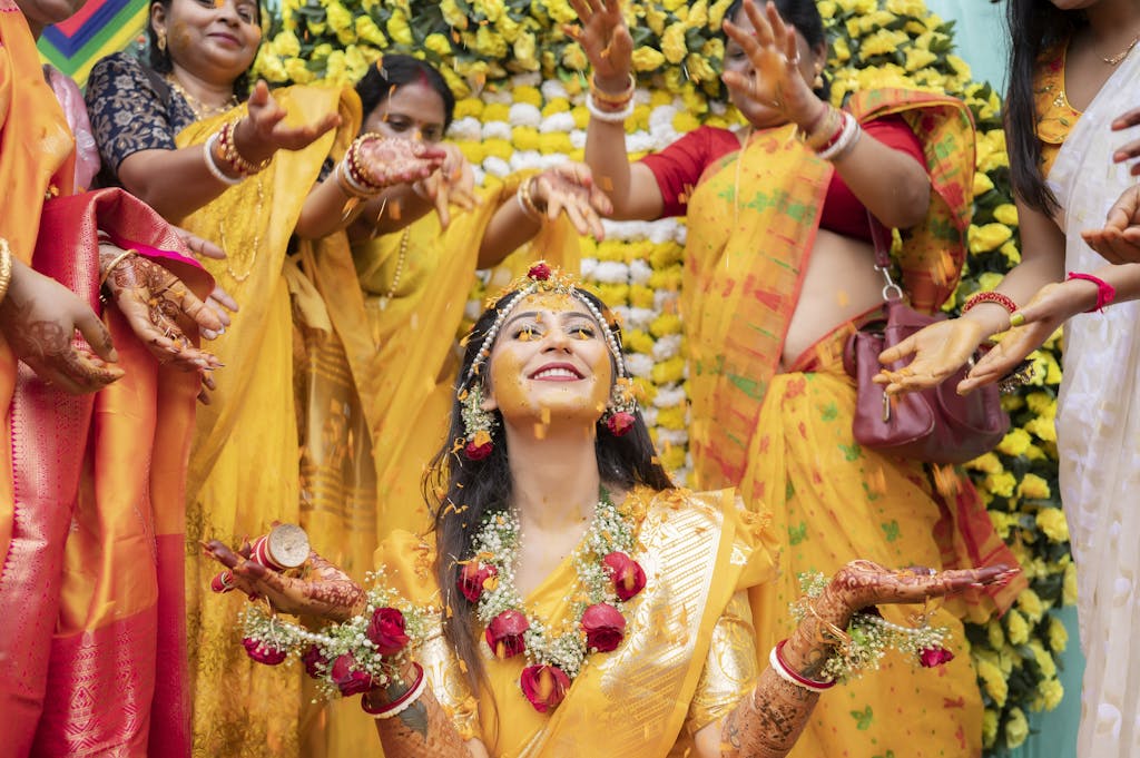 Colorful Indian Haldi ceremony with joyful women applying turmeric paste to the bride-to-be.